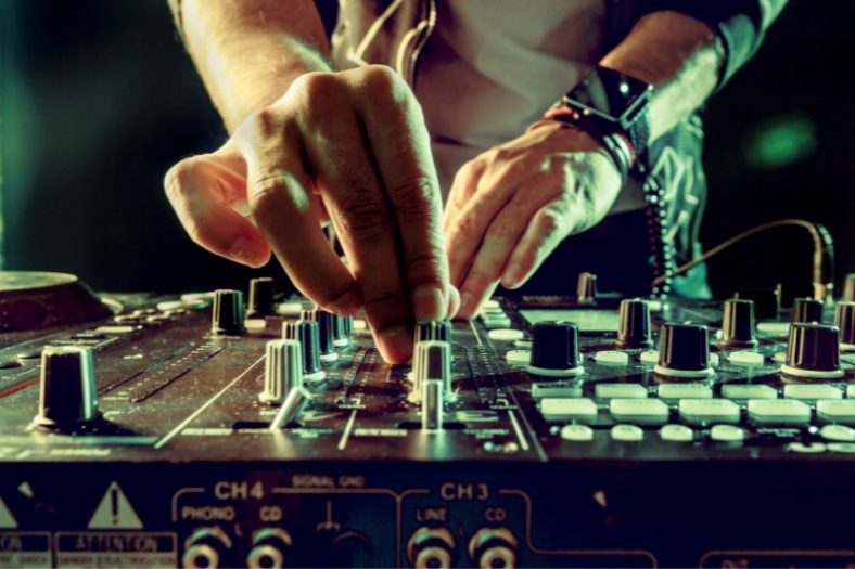 close up of a DJ's hands using a mixer 